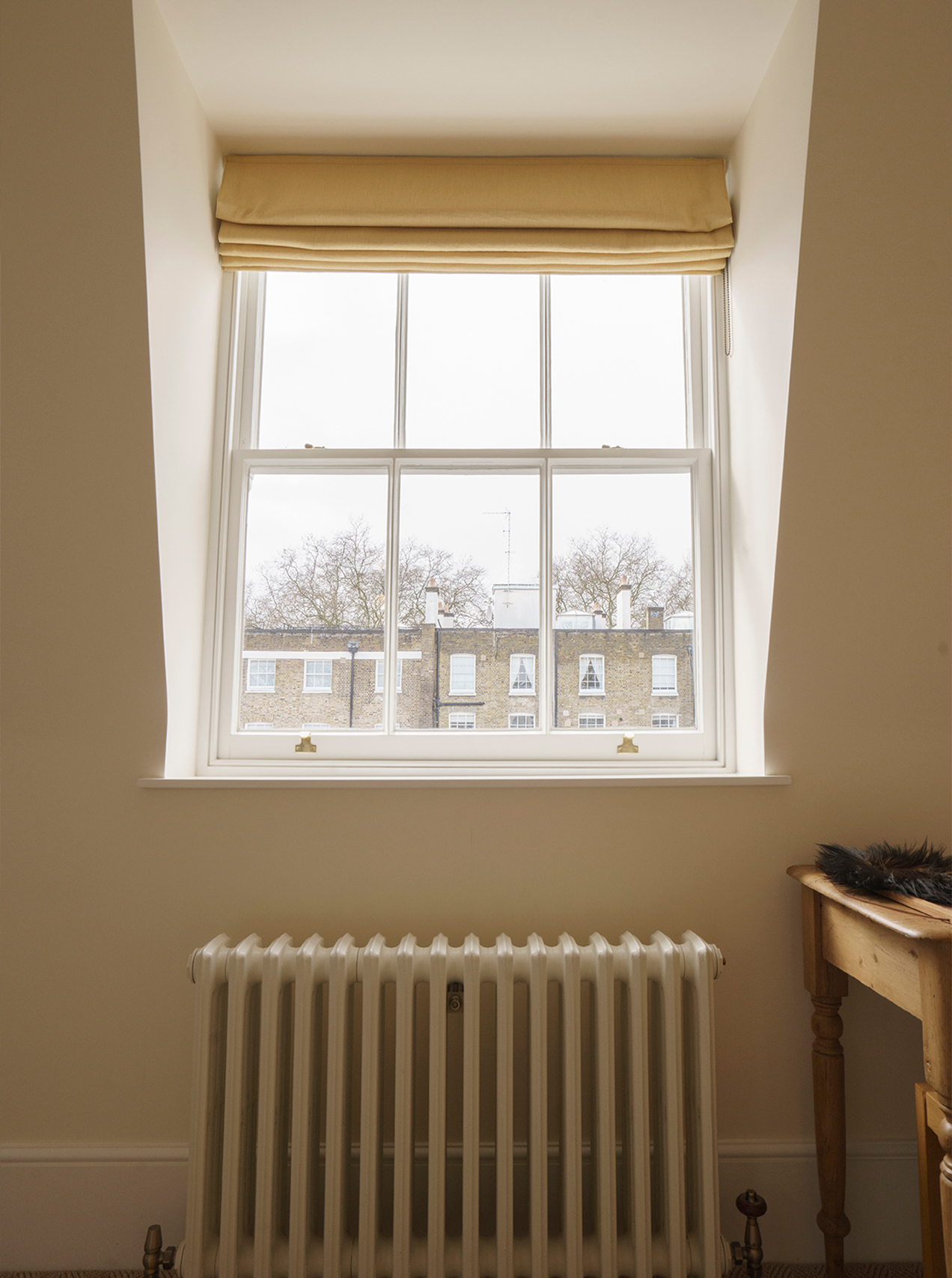 Restored Victorian fireplace within a calm residential interior by Beacham Architects, featuring bespoke joinery, soft neutral walls, and refined heritage detailing in a London home.