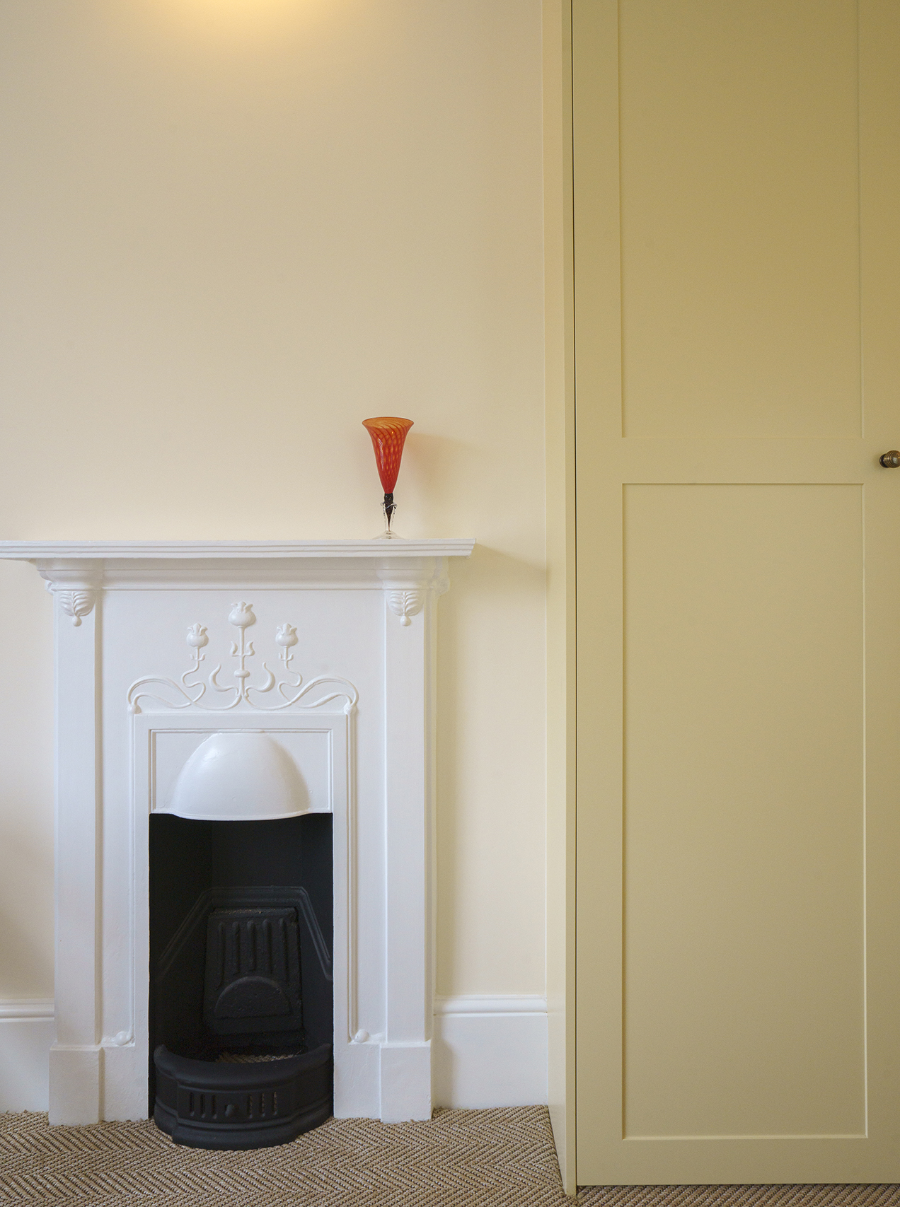 Restored Victorian fireplace within a calm residential interior by Beacham Architects, featuring bespoke joinery, soft neutral walls, and refined heritage detailing in a London home.