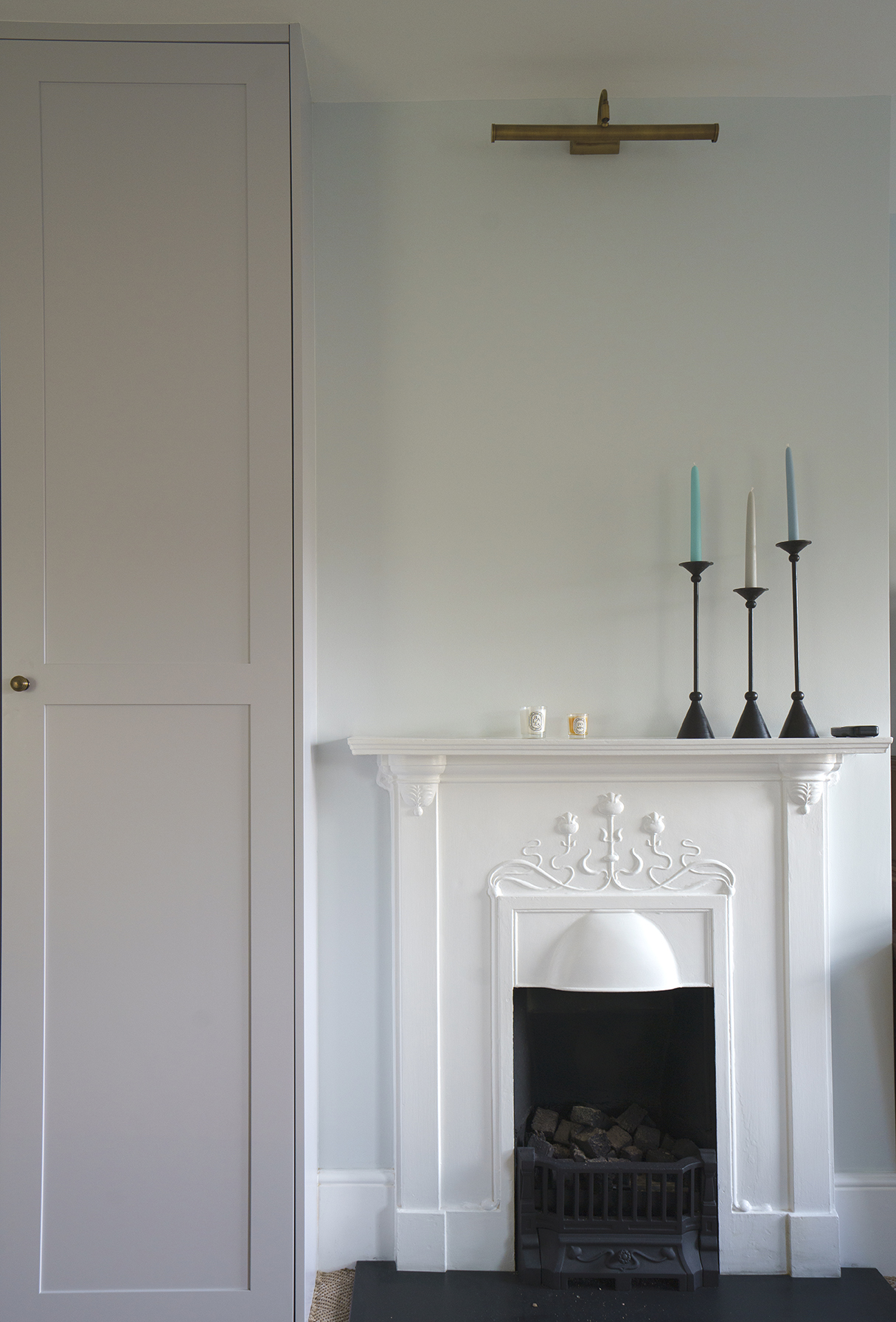 Restored Victorian fireplace within a calm residential interior by Beacham Architects, featuring bespoke joinery, soft neutral walls, and refined heritage detailing in a London home.