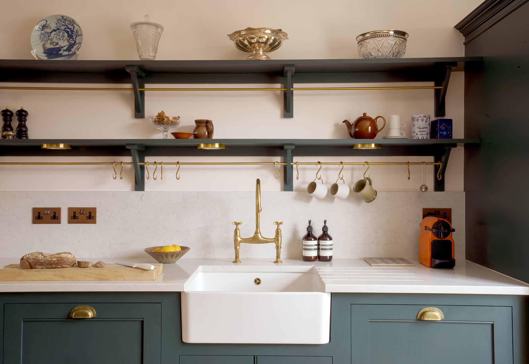 Bespoke kitchen design by Beacham Architects with open shelving, brass fixtures, shaker cabinetry, Belfast sink, and natural stone worktops in a refined London home.