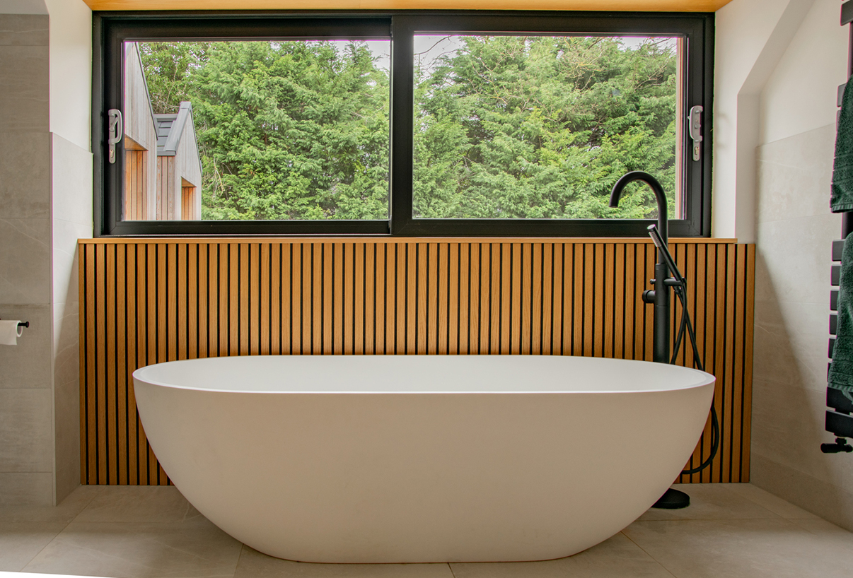Contemporary residential house designed by Beacham Architects, featuring timber-clad pitched roofs, dormer windows, and a modern reinterpretation of a traditional London home.