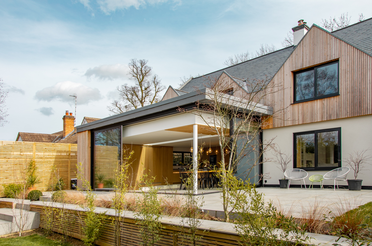 Contemporary residential house designed by Beacham Architects, featuring timber-clad pitched roofs, dormer windows, and a modern reinterpretation of a traditional London home.