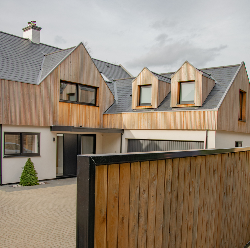 Contemporary residential house designed by Beacham Architects, featuring timber-clad pitched roofs, dormer windows, and a modern reinterpretation of a traditional London home.