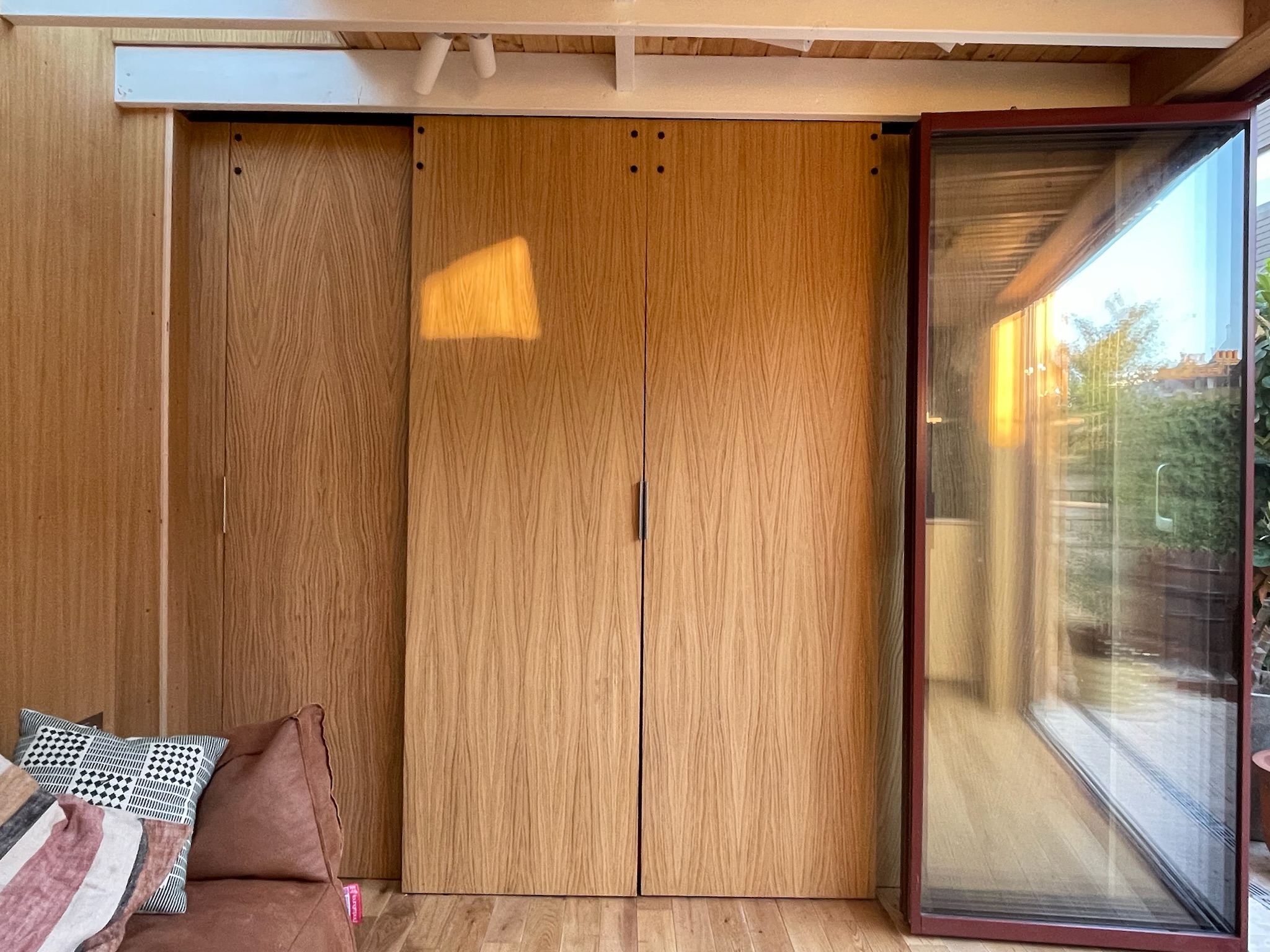A large skylight brings daylight down the back wall of the space, visually connecting the interior to the main house kitchen even when the sliding doors are closed. Full-height sliding and stacking doors create a flush threshold, blurring the line between inside and out - fully connecting the garden room into its garden.</p>
<p>