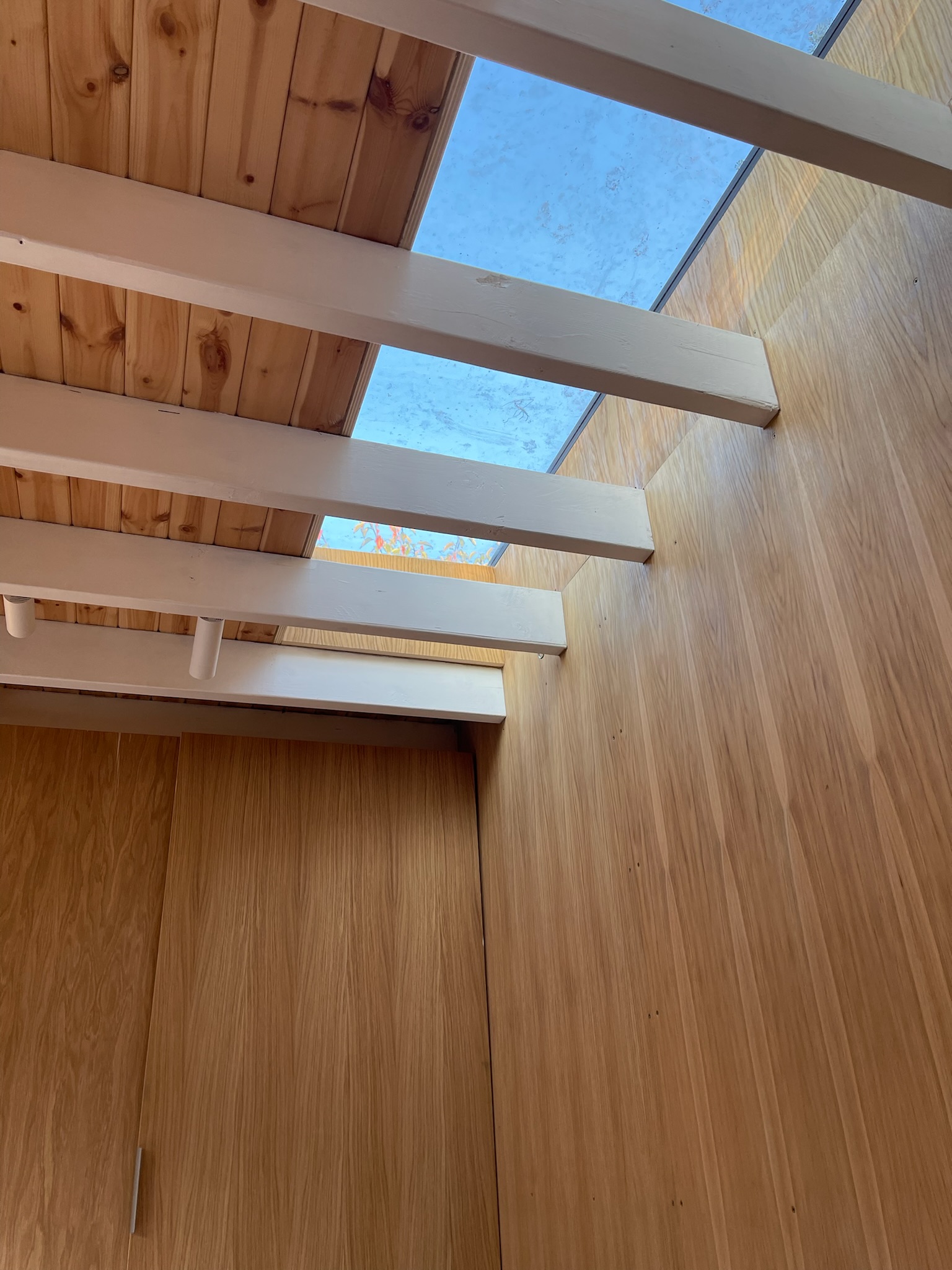 The materials palette is natural and tactile: oak timber flooring, European larch cladding, and a limestone patio provide warmth and texture. Powder-coated aluminium features and door frames in a soft oxide red take their cue from the Acer tree in the garden. Underfloor heating ensures comfort year-round.</p>
<p>The design was carefully considered to meet the needs of a young family while retaining a calm, open feel and an attractive aesthetic when viewed from the house.